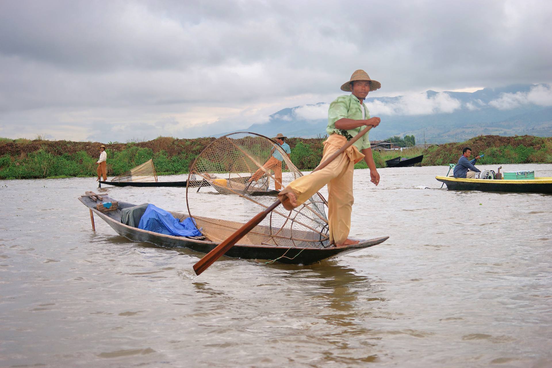 Fischer, die mit ihren Beinen rudern. Einige von ihnen sind offensichtlich vom Touristenbüro angeheuert worden, um den Touristen folkloristische Fotomotive zu bieten.